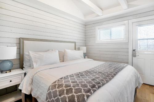 a white bedroom with a bed and a window at Driftwood Resort on the Ocean in Montauk