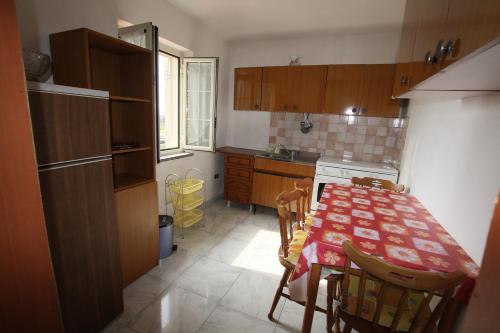 a kitchen with a table and chairs and a kitchen with a table and a table at Appartamento Terry - Casa vacanze in Capo Vaticano