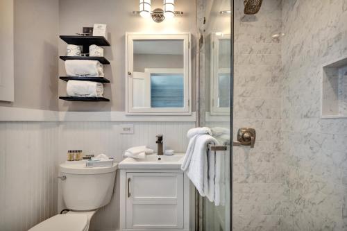 a bathroom with a toilet and a sink and a shower at Driftwood Resort on the Ocean in Montauk