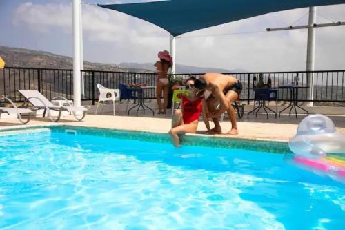two people are playing in a swimming pool at Panoramic Holidays - Premium 8 in Peyia