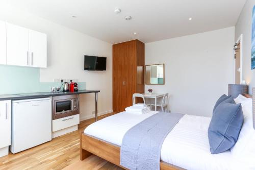 a bedroom with a large bed and a kitchen at Russell Square Serviced Apartments by Concept Apartments in London