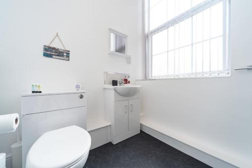 uma casa de banho branca com um WC e um lavatório em Jesouth Refreshing Condo Roomy Comfy Posh em Hull