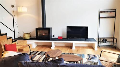 a living room with a fireplace and a tv at Casa adosada moderna en Guils in Guils de Cerdaña