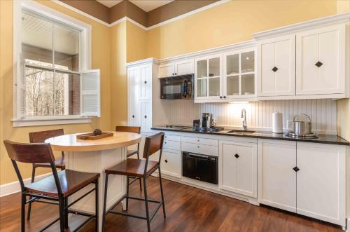 a kitchen with white cabinets and a table and chairs at Inn at Diamond Cove in Portland