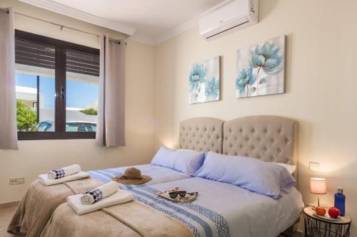 een slaapkamer met 2 bedden, handdoeken en een raam bij Villa Estrella by Villa Plus in Playa Blanca