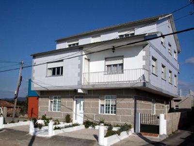 un gran edificio blanco con una valla delante en Casa Laura Sanxenxo, en Sanxenxo