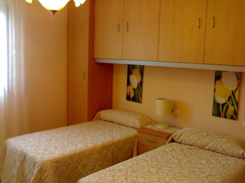 Habitación de hotel con 2 camas y armario en Casa Laura Sanxenxo, en Sanxenxo