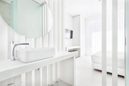 a white bathroom with a sink and a mirror at Vila Maria Hotel - Adults Only in Albufeira