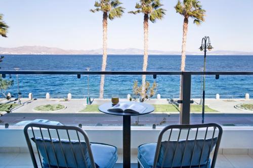 a view of the ocean from a balcony with palm trees at KoSea Boutique Hotel in Kos Town