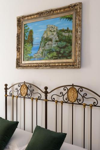a painting above a bed in a bedroom at Delfini Trevi House in Rome