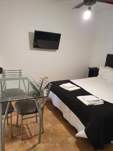 sypialnia z łóżkiem ze szklanym stołem i telewizorem w obiekcie Naranja w mieście Rosario