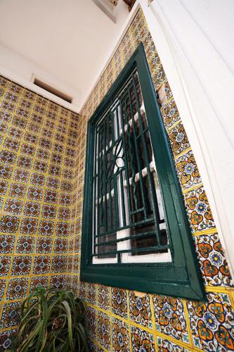 a window on the side of a building with tiles at DAR EL HAMRA in Mahdia