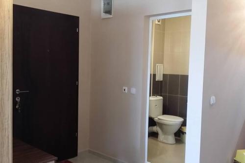 a bathroom with a toilet and a black door at Studio in the center of Sarafovo in Burgas