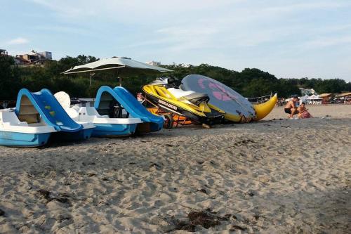 a group of boats on a beach with an umbrella at Studio in the center of Sarafovo in Burgas City