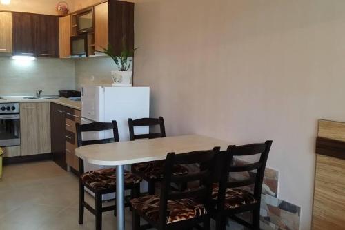 a kitchen with a table and chairs and a refrigerator at Studio in the center of Sarafovo in Burgas City