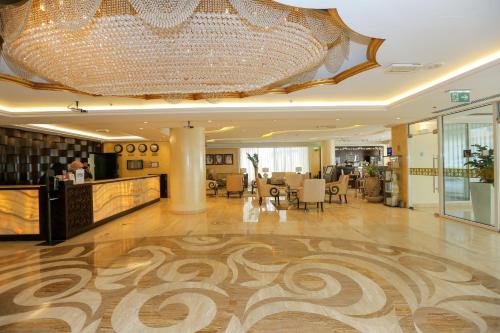 a large lobby with a large chandelier in a building at Ivory Grand Hotel Apartments in Dubai