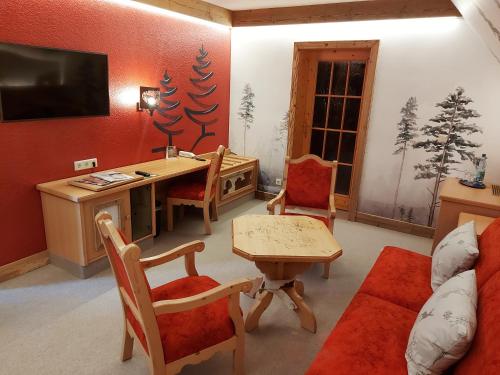a living room with a desk and a table at Hotel und Restaurant Köhlerhütte - Fürstenbrunn in Grünhain-Beierfeld
