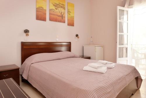 a bedroom with a bed with two towels on it at Hotel Villa Plaza in Spetses