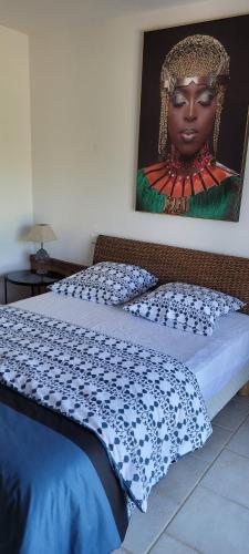 a bedroom with a bed with a painting on the wall at La Boissière, Le Domaine de Brugal in Carsac-Aillac