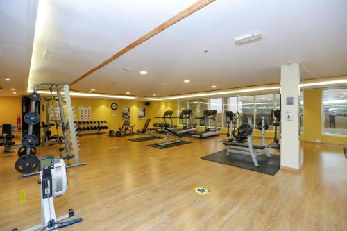 a gym with treadmills and machines in a room at Ivory Grand Hotel Apartments in Dubai