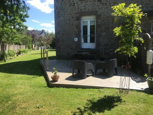 een patio met stoelen en een tafel in de tuin bij La Jackal in Ploubezre