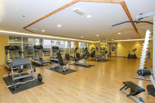 a gym with treadmills and exercise equipment in a building at Ivory Grand Hotel Apartments in Dubai