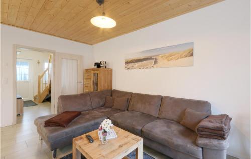 a living room with a brown couch and a table at Ferienhaus Seemöve Altefähr in Altefähr