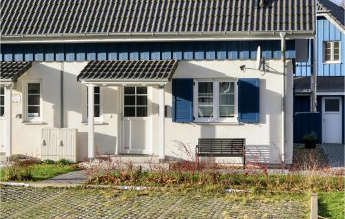 a white house with blue doors and a bench at Ferienhaus Seemöve Altefähr in Altefähr