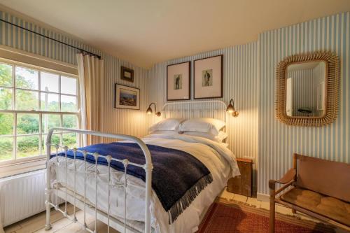 a bedroom with a bed and a mirror at Haclins Cottage - Norfolk Holiday Properties in Fakenham
