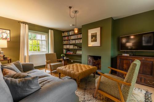 a living room with a couch and a tv at Host & Stay - Haclins Cottage in Fakenham