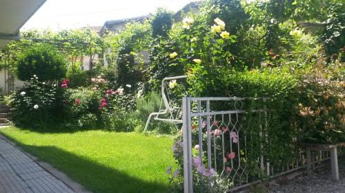 a garden with a white gate and flowers at Family Hotel "May" in Petrich