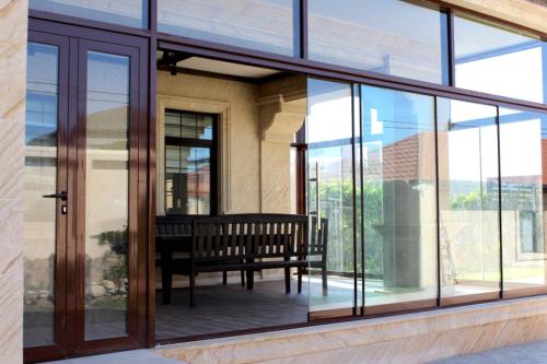 a balcony with a bench in a building with glass windows at Villa Gilavar in Baku