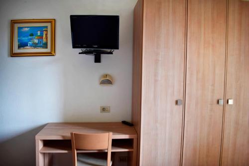 Pokój z biurkiem i telewizorem na ścianie w obiekcie Hotel Gattuccio w Cesenatico
