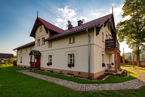 a large white house with a red roof at Dworek Wojanów in Wojanów