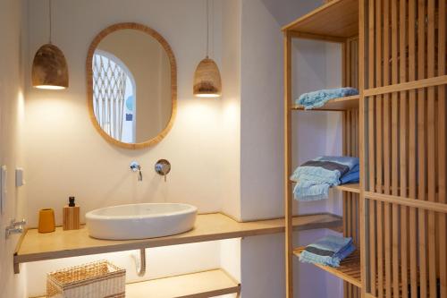 a bathroom with a sink and a mirror at Spiliada Boutique Studios in Batsi