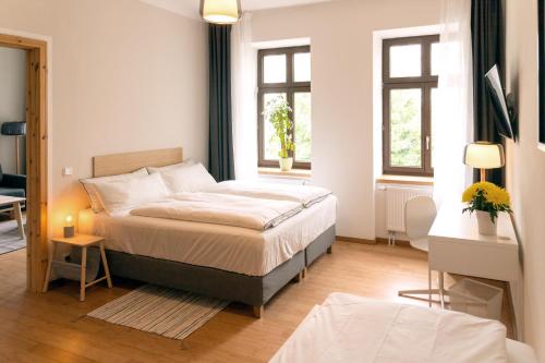 ライプツィヒにあるarena guest apartmentのベッドルーム1室(ベッド1台、窓2つ付)