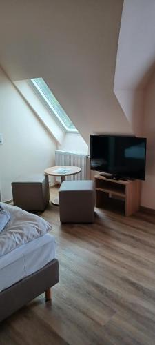 a bedroom with a flat screen tv and a bed at Pension am Stern in Leipzig