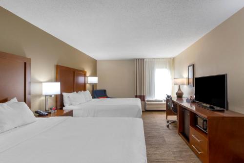 a hotel room with two beds and a flat screen tv at Comfort Inn University Durham - Chapel Hill in Durham