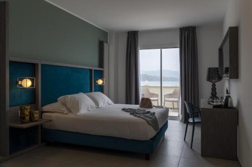 a bedroom with a large bed and a view of the ocean at Resort La Battigia Beach & Spa in Alcamo Marina