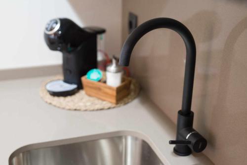 a kitchen sink with a black faucet on a counter at Apartamento rural Las Cañas Esencia de Bardenas in Villafranca