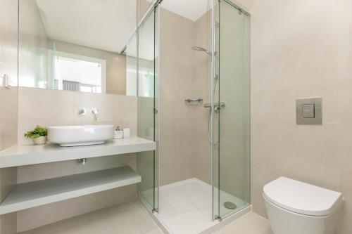 a bathroom with a shower and a toilet and a sink at Casa Branca 40 in Lagos