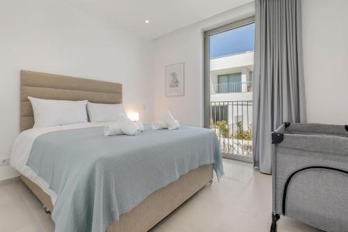 a white bedroom with a bed and a window at Casa Branca 40 in Lagos