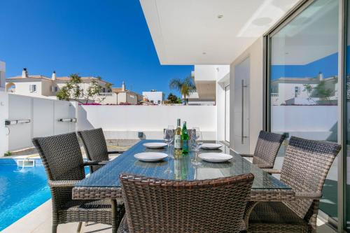 a dining room with a table and chairs and a pool at Casa Branca 40 in Lagos