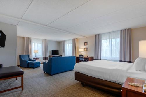 Habitación grande con cama, escritorio y silla. en Comfort Inn The Pointe, en Niagara Falls