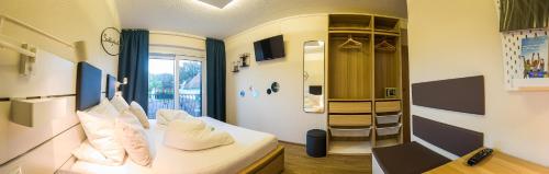a room with a bed with white pillows on it at Pension Julia & Haus Elisabeth - Wallner's Hofheuriger & Weinhof in Mörbisch am See