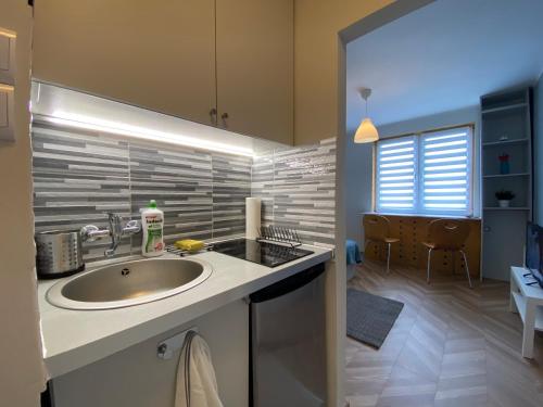 łazienka z umywalką oraz pokój ze stołem w obiekcie Apartament Sopot Oliwia III w mieście Sopot
