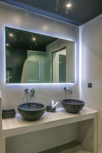 two sinks in a bathroom with a mirror at Sunset junior suites in Agios Ioannis Tinos