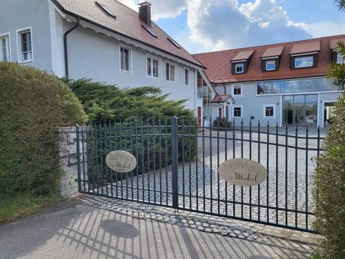 a metal gate in front of a white house at Ferienhof Gutmichel in Feuchtwangen