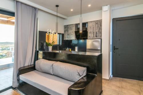 a kitchen with a bench in front of a counter at Sunset junior suites in Agios Ioannis Tinos