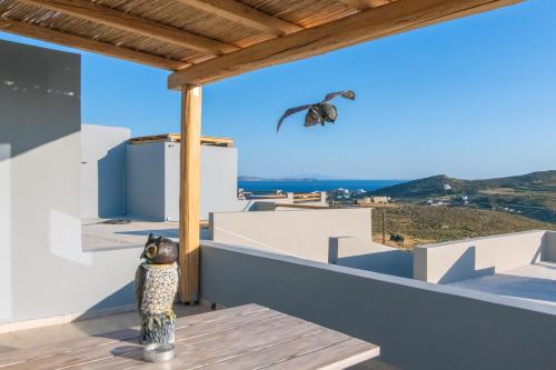 a bird statue sitting on a balcony looking at a moth at Sunset junior suites in Agios Ioannis Tinos